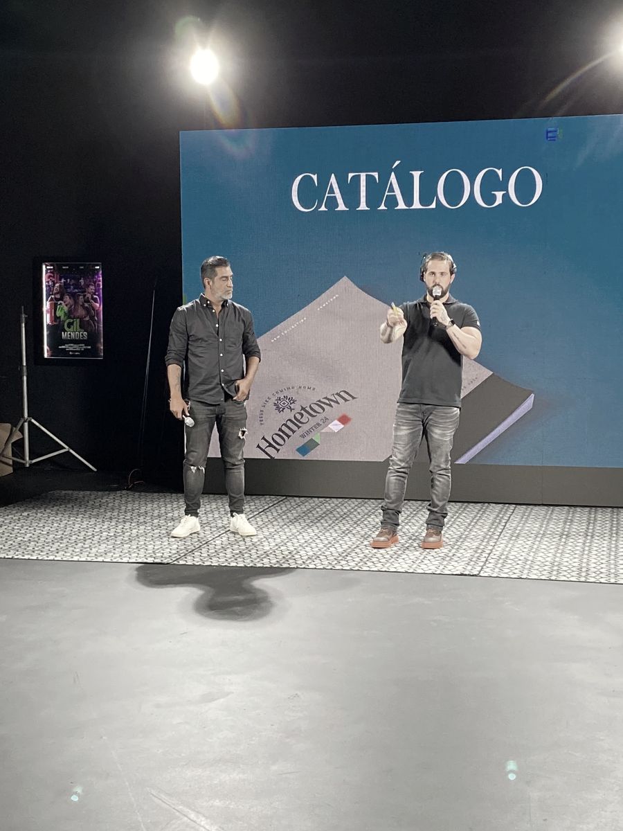Caiube apresentando um catálogo em palco com telão